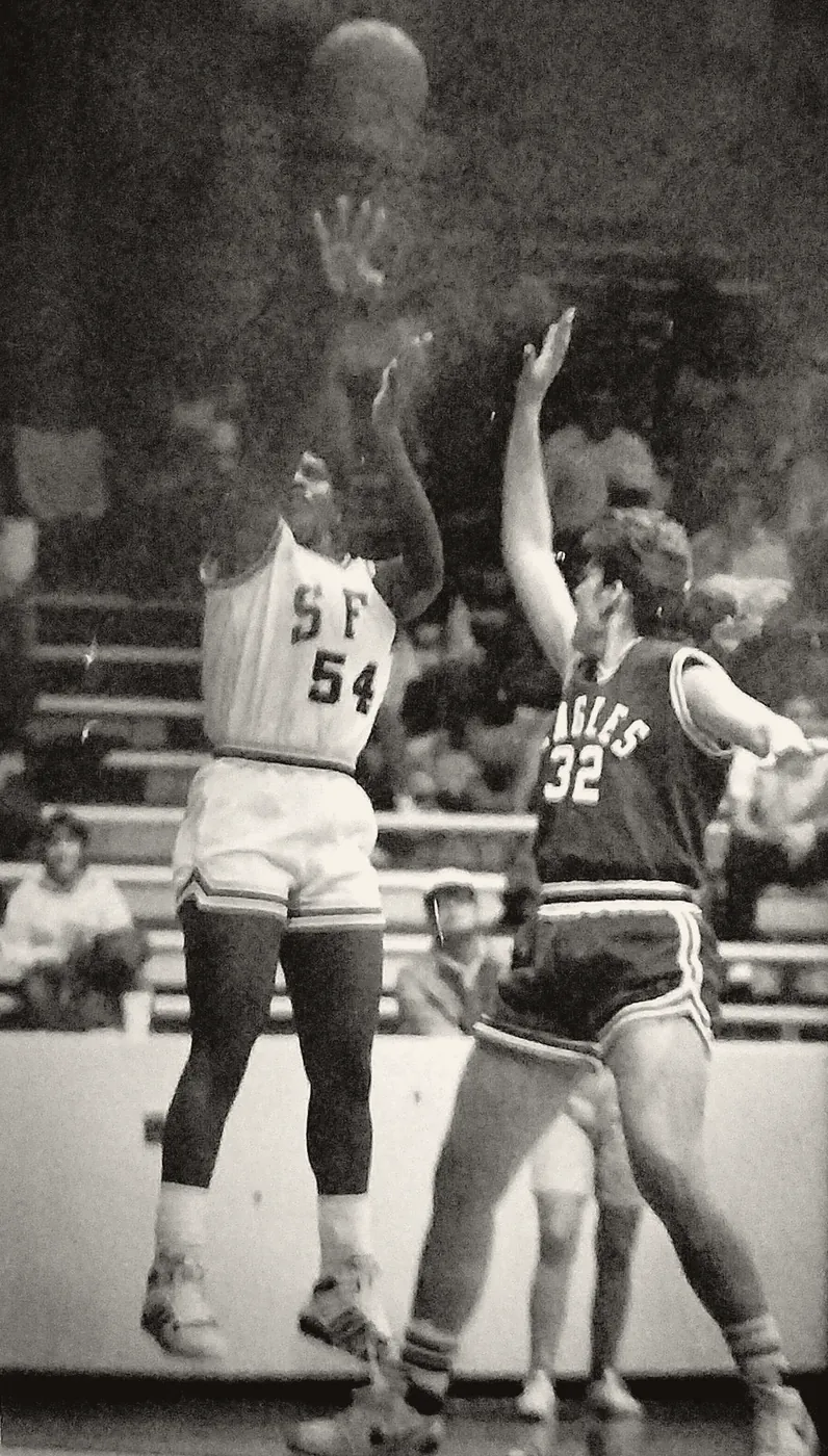 Annie Norris, number 54, rising for a jump shot with a defender&rsquo;s hand up